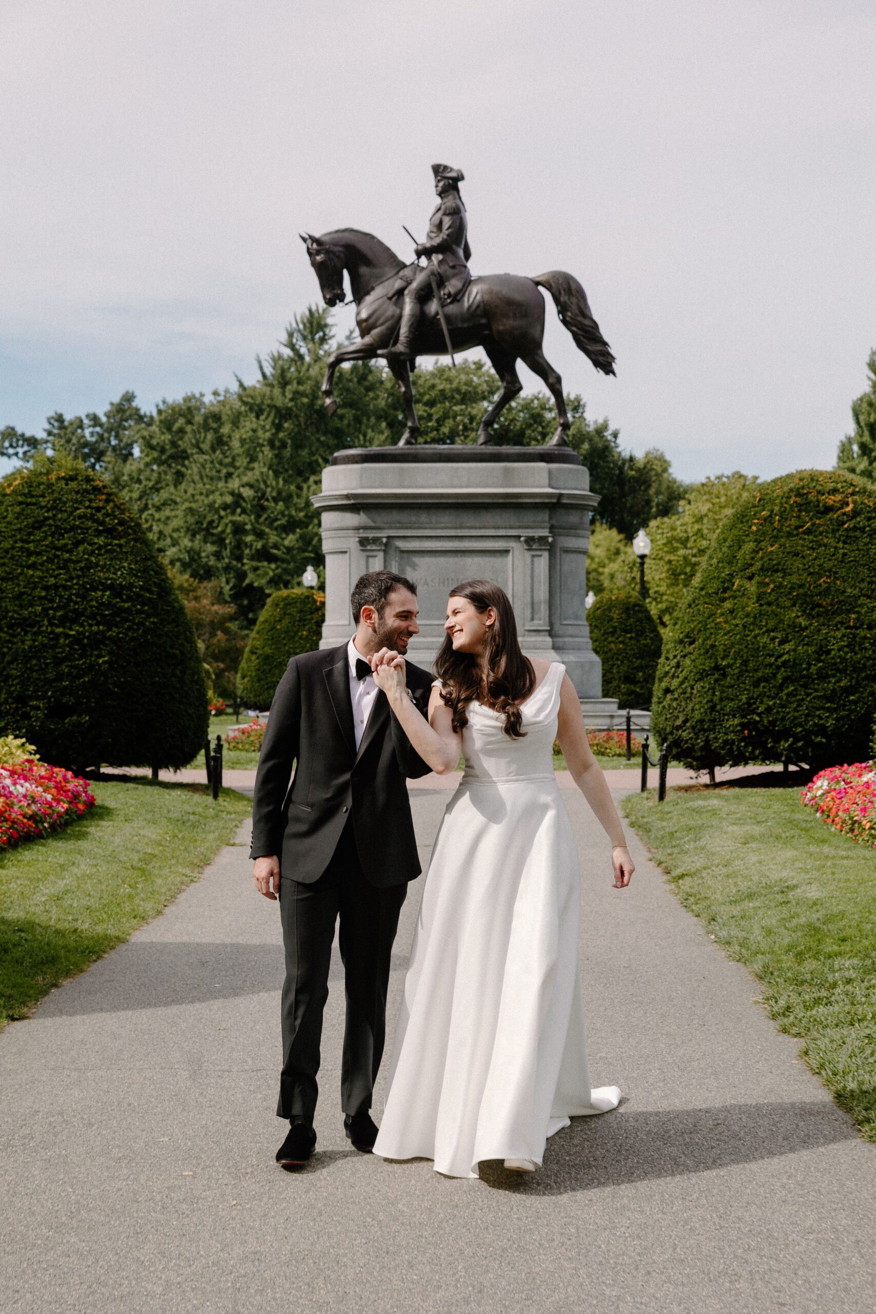 Bride and groom walking through the Boston Public Garden wedding location after their ceremony.